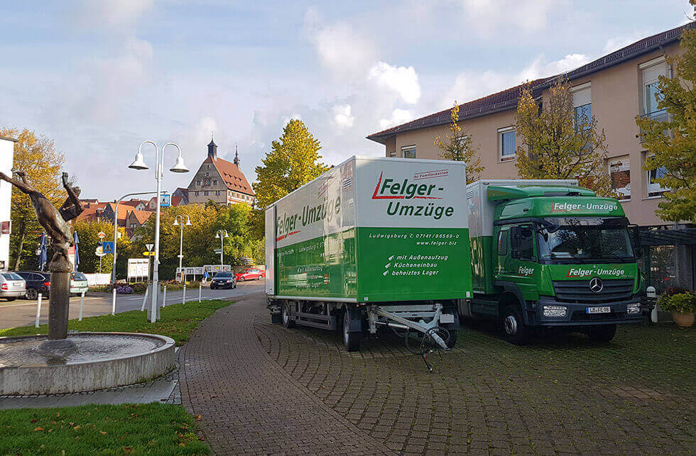 LKW und Anhänger von Felger GmbH stehen nebeneinander auf einem Parkplatz im Stadtinneren LKW und Anhänger von Felger GmbH stehen nebeneinander auf einem Parkplatz im Stadtinneren