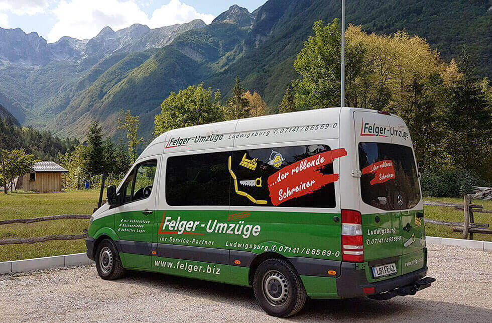 Transporter von Felger GmbH steht auf einer Parkfläche mit Bergen im Hintergrund Transporter von Felger GmbH steht auf einer Parkfläche mit Bergen im Hintergrund